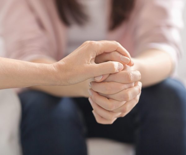 Loneliness, despair, depression concept. Close up of therapist touching woman patient hands during session